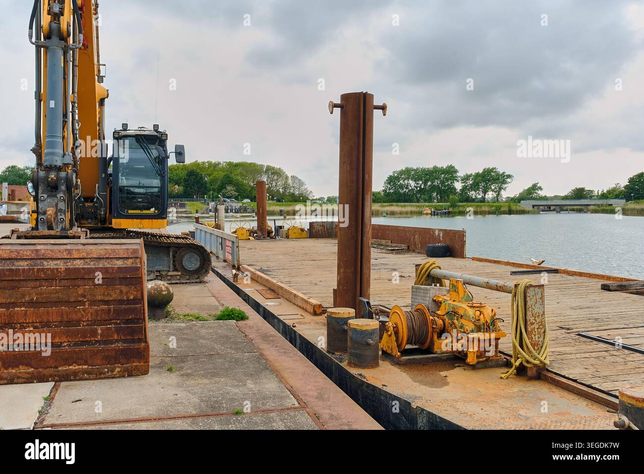 Attrezzature per l'edilizia pesante presso Una banchina di carico per vie navigabili per lo sviluppo di infrastrutture e il settore marino Foto Stock