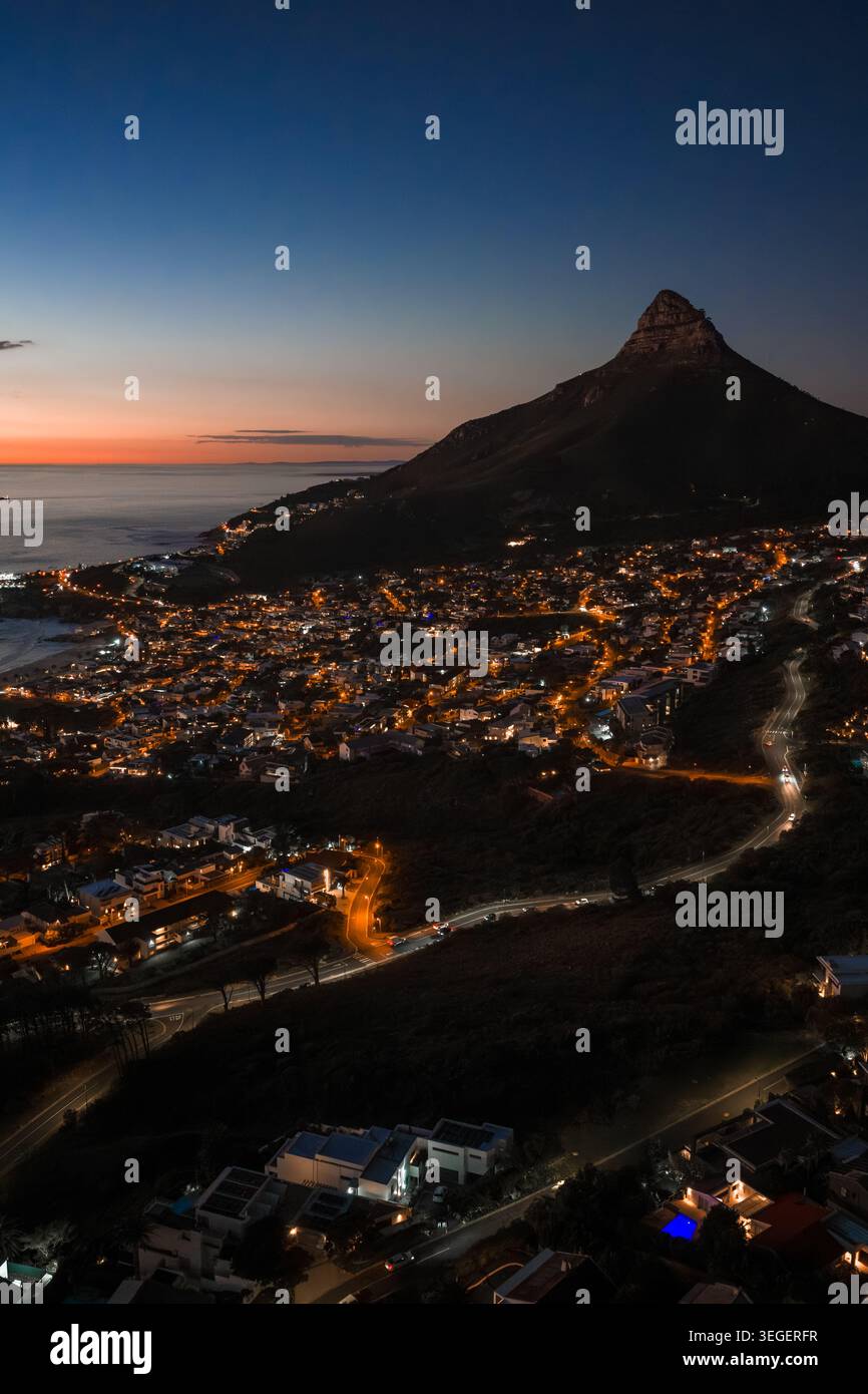 Crepuscolo aereo su città del Capo con le luci di Lion's Head e Camps Bay Foto Stock