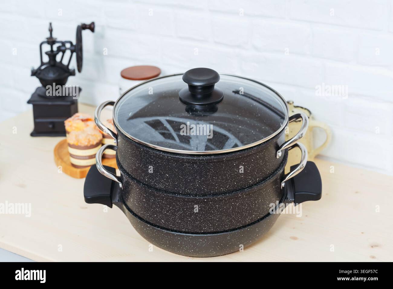 Angolo cucina artigianale con macinacaffè d'epoca e recipiente per la cottura a vapore in un'atmosfera calda Foto Stock