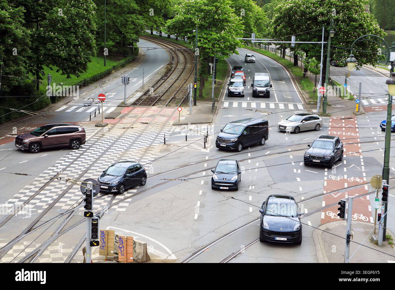 Trafficato incrocio stradale alberato a Bruxelles, Belgio Foto Stock