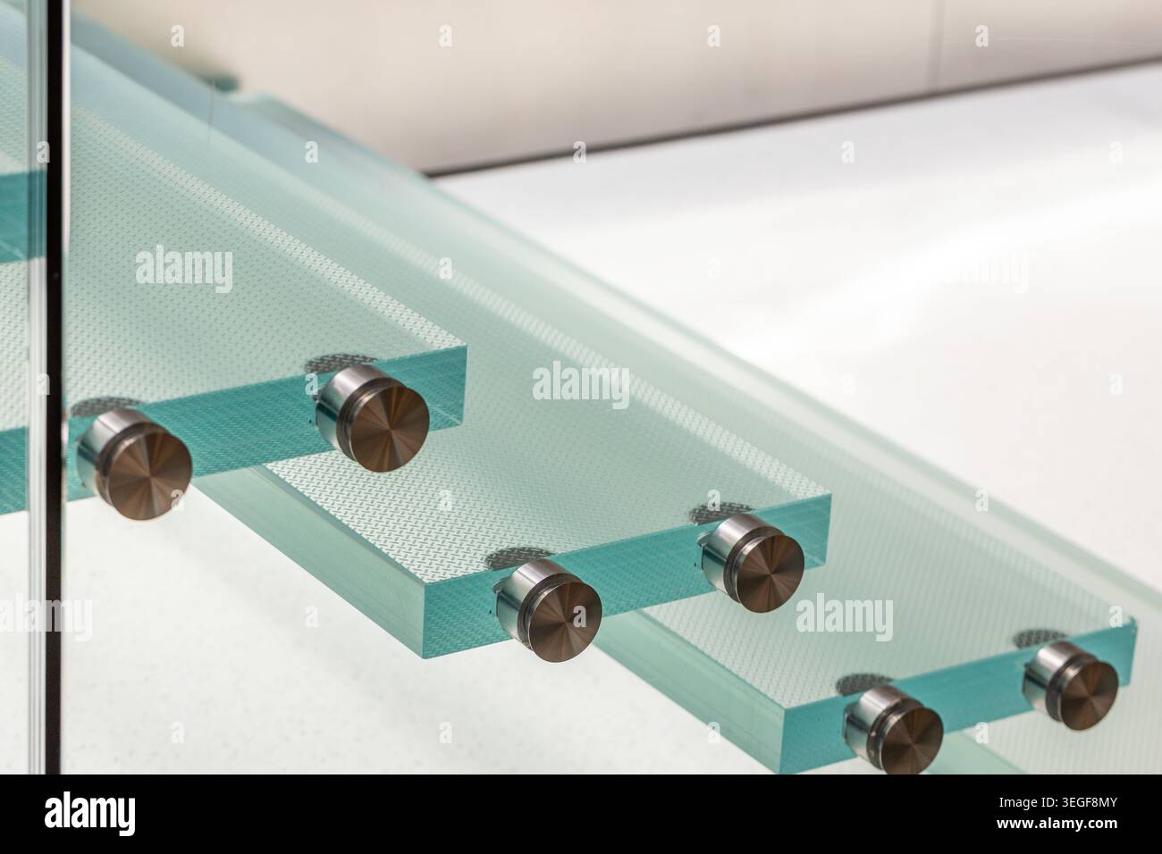 Primo piano dei pannelli in vetro di sicurezza laminato con superficie antiscivolo e antiscivolo, fissati con supporti in vetro con fissaggio a punti in metallo (distanziatori). A ad alta tecnologia Foto Stock