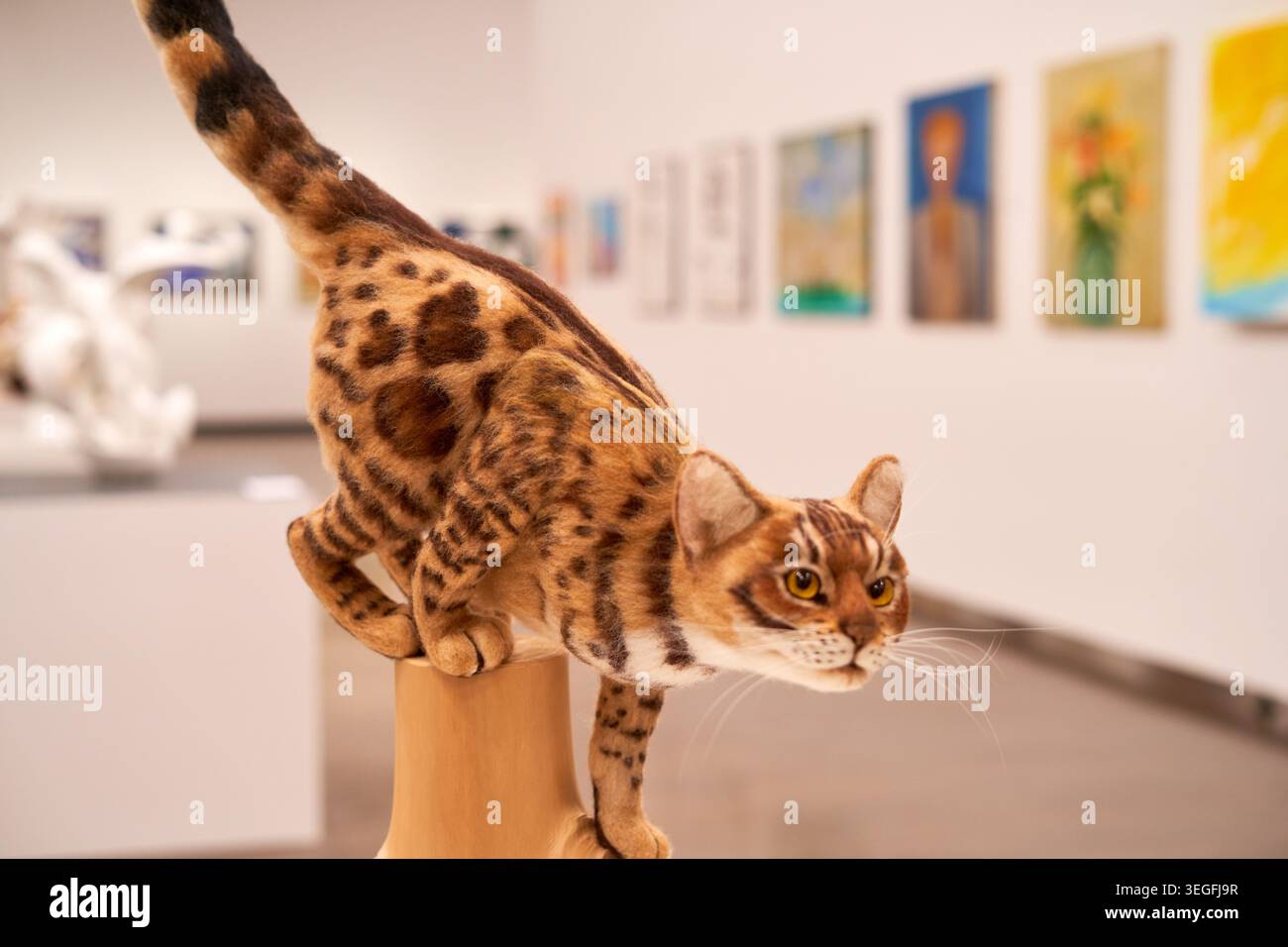 Una figura iperrealistica di tassidermia o scolpita di un piccolo gatto selvatico maculato con un caratteristico pelo a motivo di rosette in sfumature di marrone, nero e marrone chiaro Foto Stock