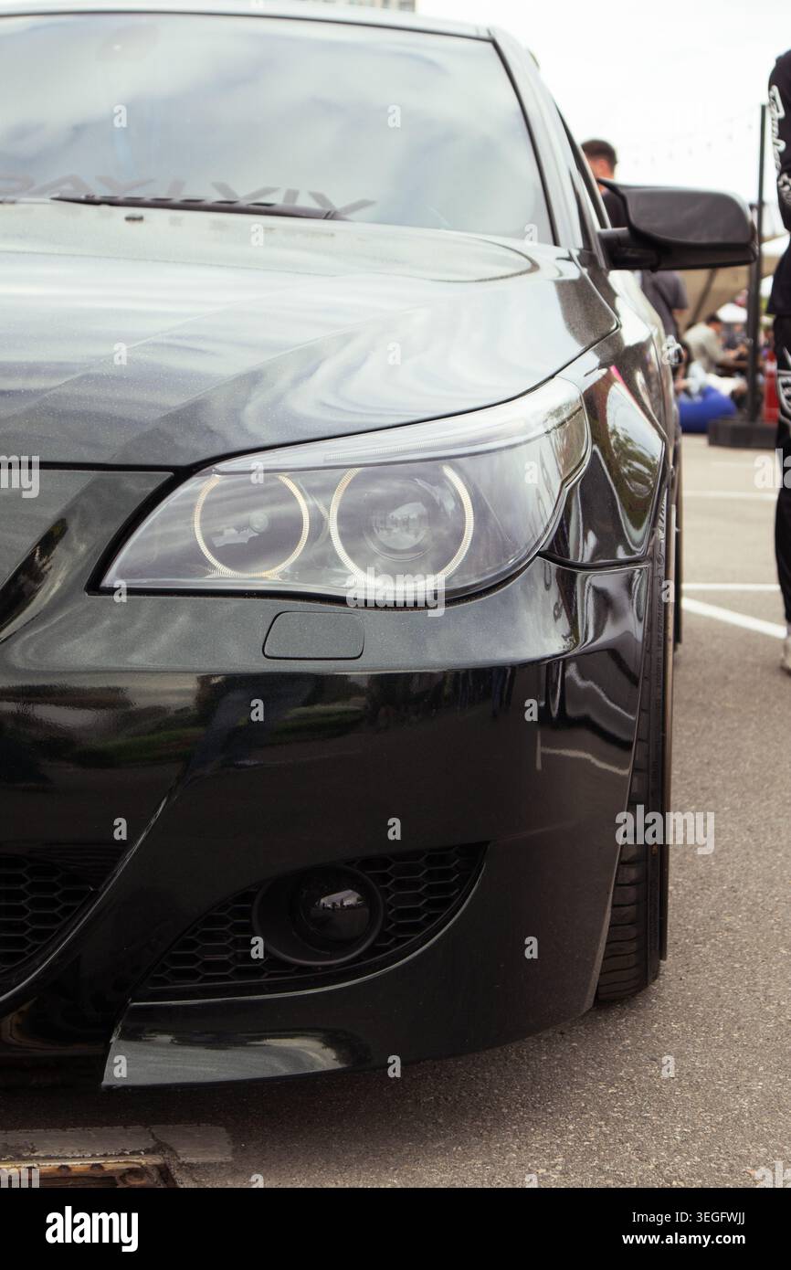 Berlina lucida con dettagli audaci. Elegante auto nera con vernice lucida e paraurti dal design aggressivo Foto Stock