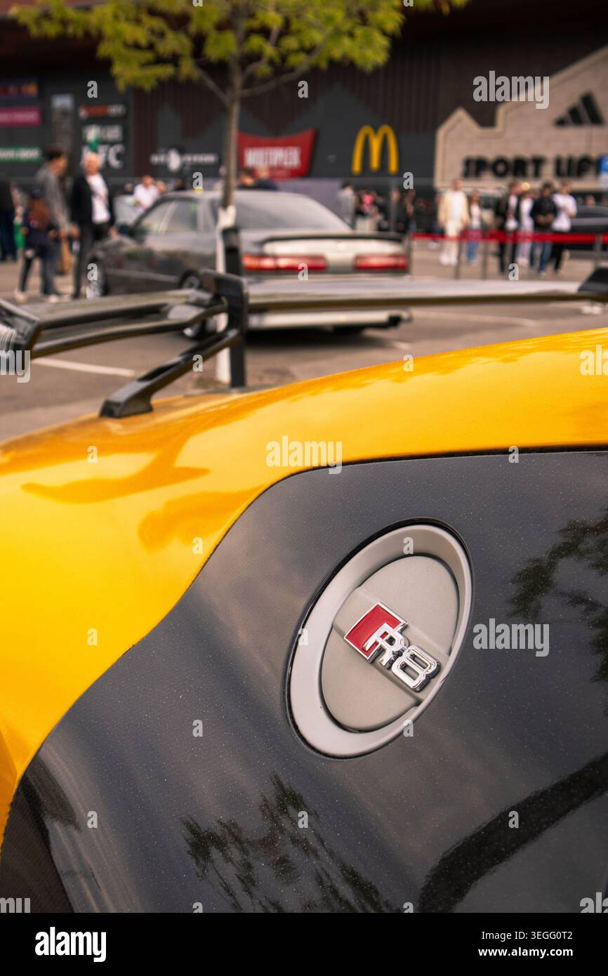 Prospettiva intima che mostra una vivace auto sportiva con dettagli scintillanti e emblema riflettente Foto Stock