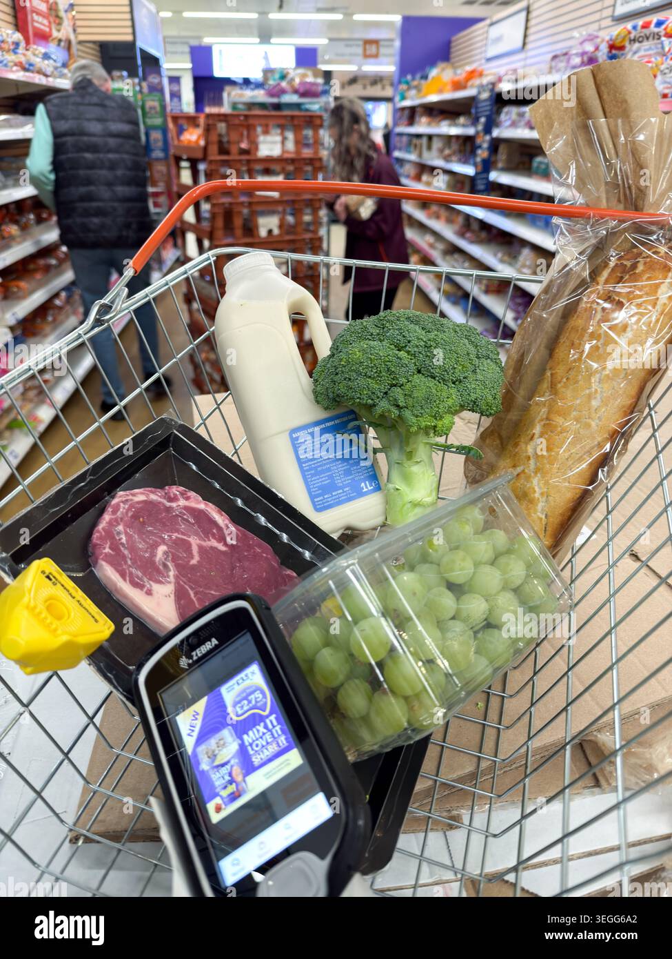 Uno scanner per codici a barre SmartShop di Sainsbury tiene traccia dei costi di gestione di carne, latte e generi alimentari di base in un carrello per supermercati a Londra, maggio 2026 Foto Stock