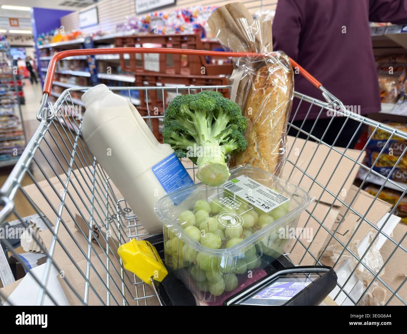 Generi alimentari essenziali in un cestino di supermercati a Londra, fotografati in mezzo all'aumento dell'inflazione dei prezzi alimentari causata dal conflitto in Medio Oriente del 2026 Foto Stock