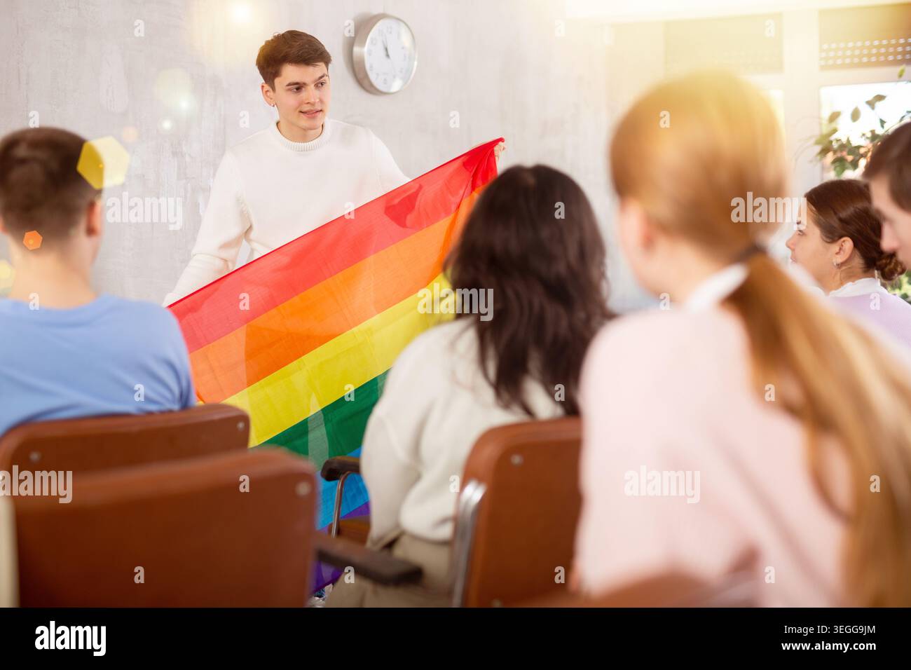 Lo studente racconta ai suoi compagni l'essenza della LGBT che detiene la bandiera arcobaleno Foto Stock
