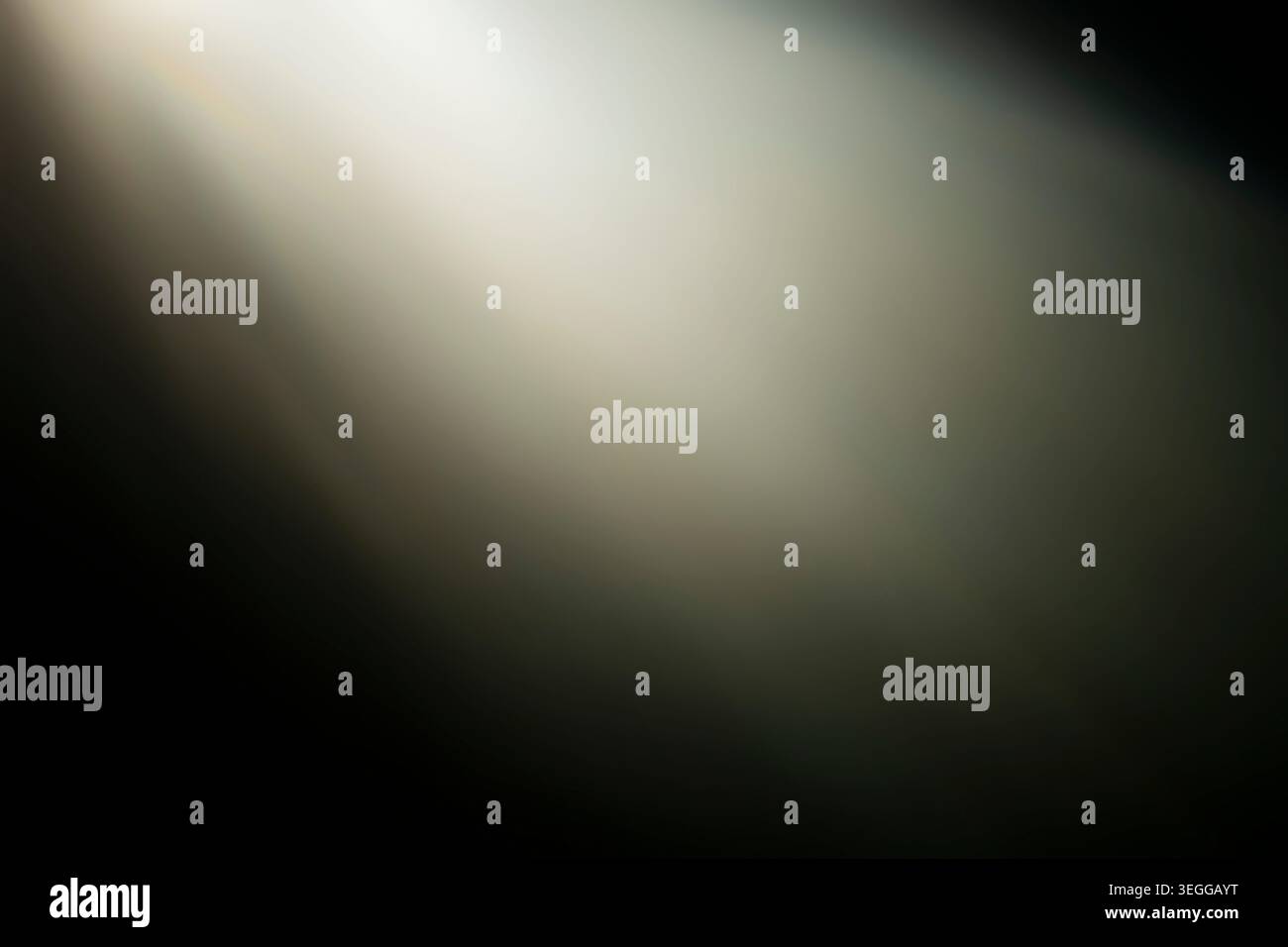 I raggi di luce calda e brillante brillano diagonalmente su uno sfondo scuro astratto creando una sovrapposizione luminosa morbida Foto Stock