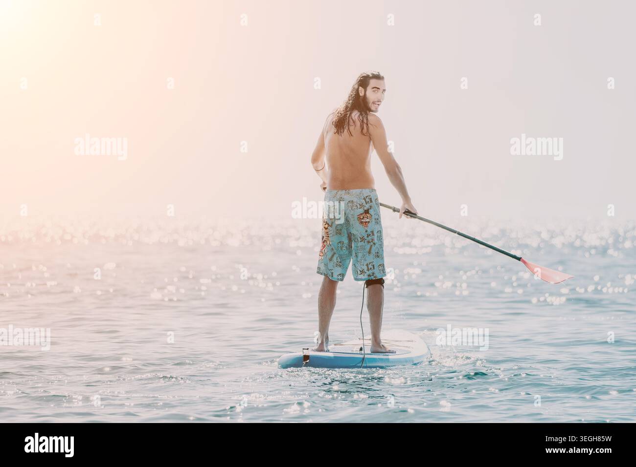 Paddleboard, Man, Ocean: Un uomo paddleboard nell'oceano in una giornata di sole. Foto Stock