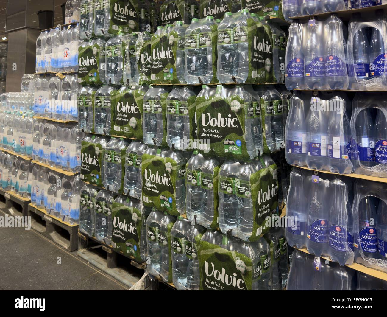 Acqua minerale acqua potabile in bottiglia confezionata in bottiglie in PET in polietilene tereftalato impilate su pallet per lo stoccaggio, internazionale Foto Stock