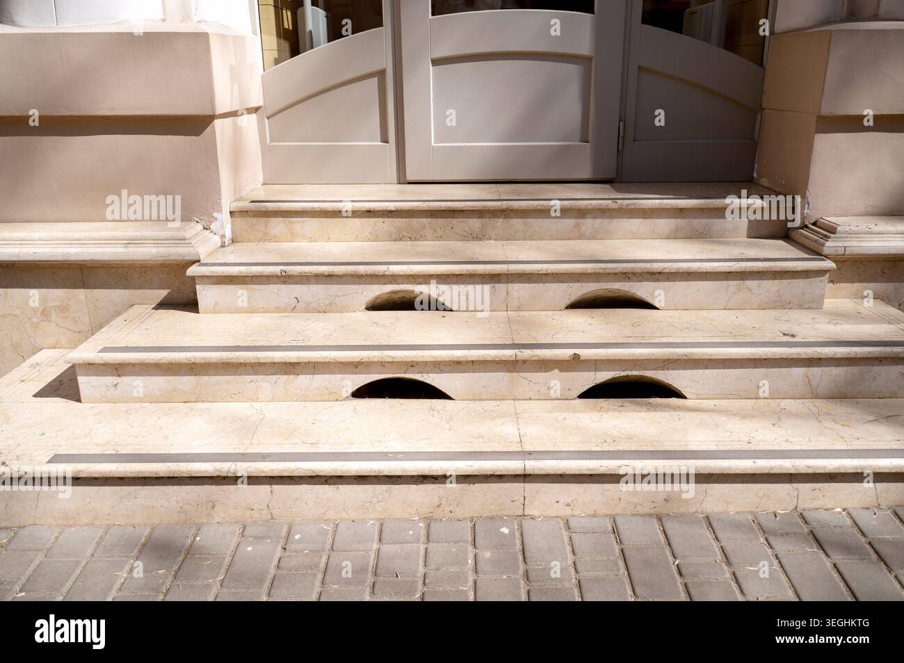 Primo piano di scale di marmo chiaro che mostrano la struttura in pietra naturale e motivi d'ombra. Concetto di finiture architettoniche di fascia alta, lavori in muratura solida, e. Foto Stock