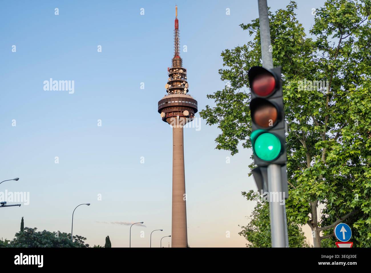Madrid, Spagna; 6 maggio 2026: Torre delle telecomunicazioni di Torrespaña che sorge sopra una strada trafficata di Madrid, Spagna, con semaforo verde, al tramonto. Foto Stock