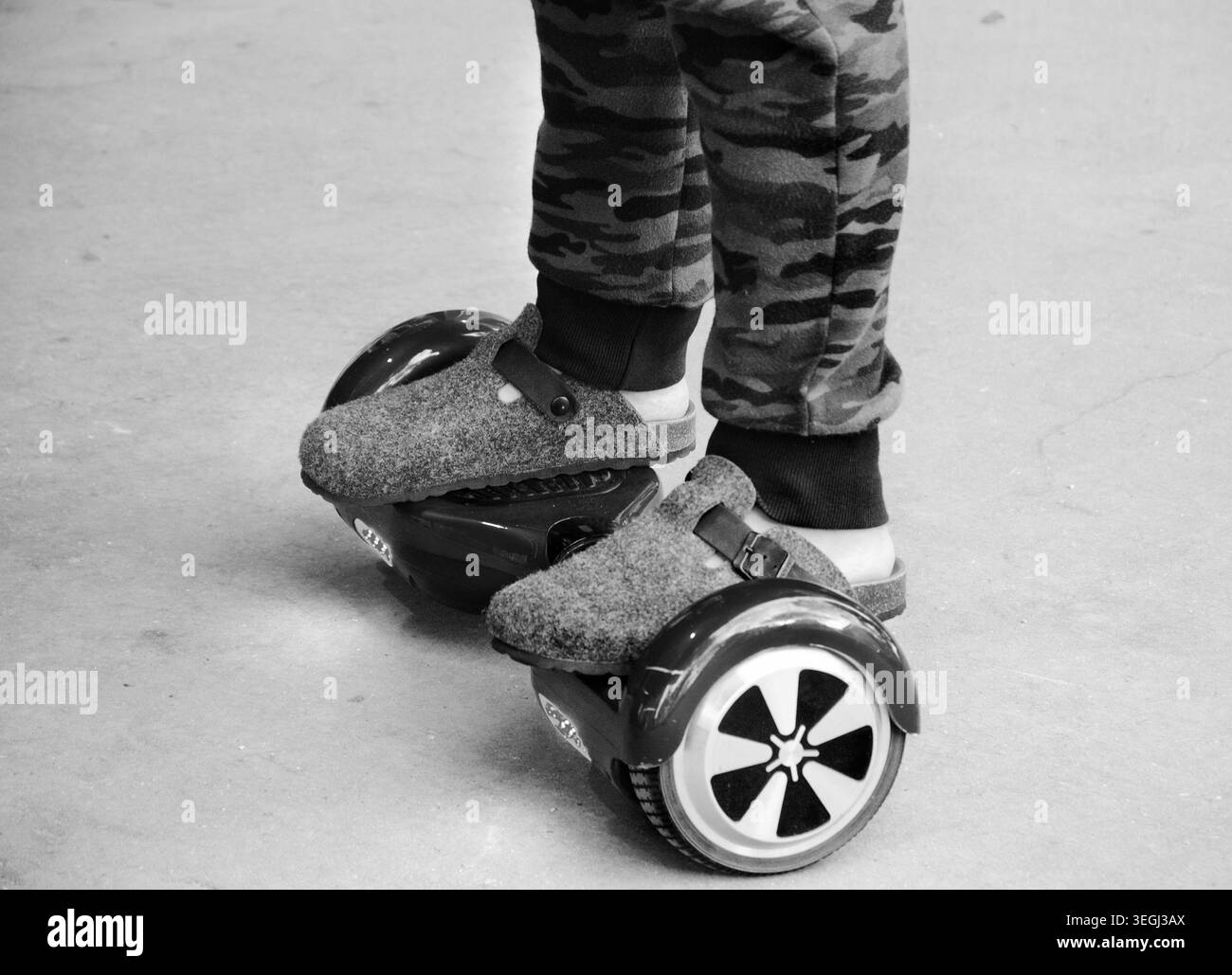Piedi di un uomo in sella a uno scooter elettrico auto-bilanciante, foto storica in bianco e nero Foto Stock
