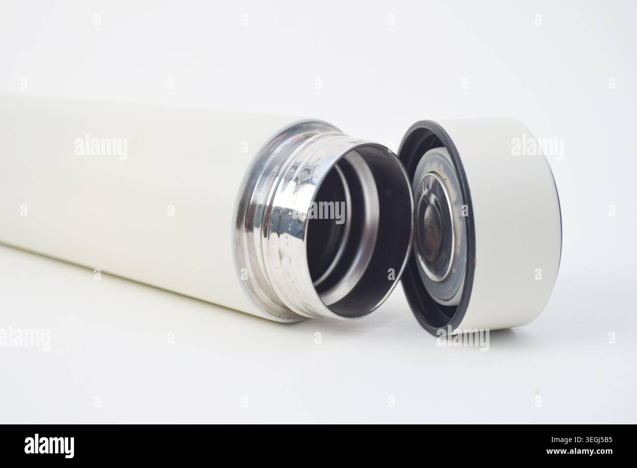 Flacone termos vuoto vuoto aperto con bordo interno metallico e tappo del coperchio su sfondo bianco. Foto Stock