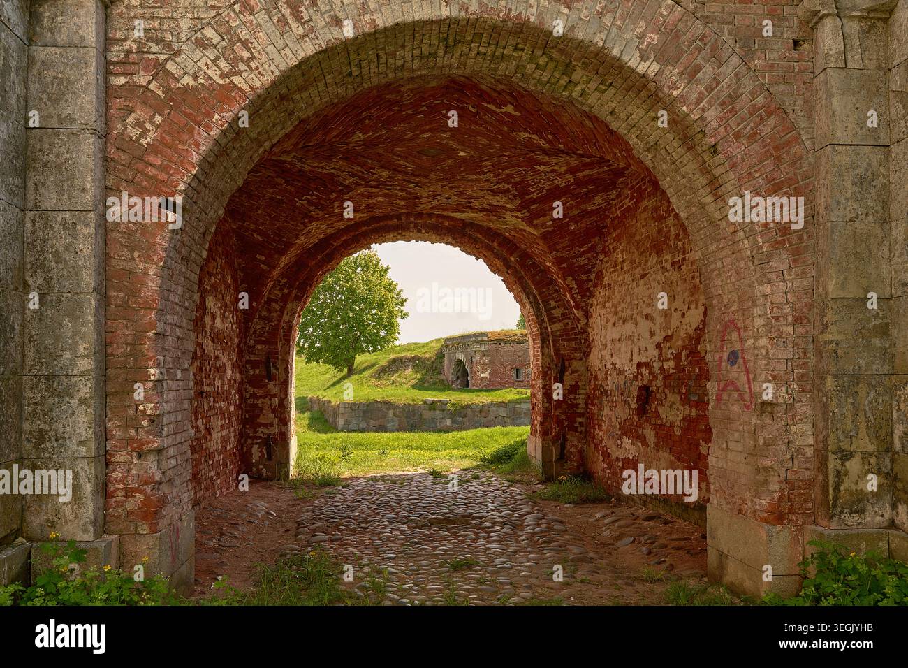 Primo piano di mattoni e archi di pietra nelle rovine della fortezza storica. Foto Stock