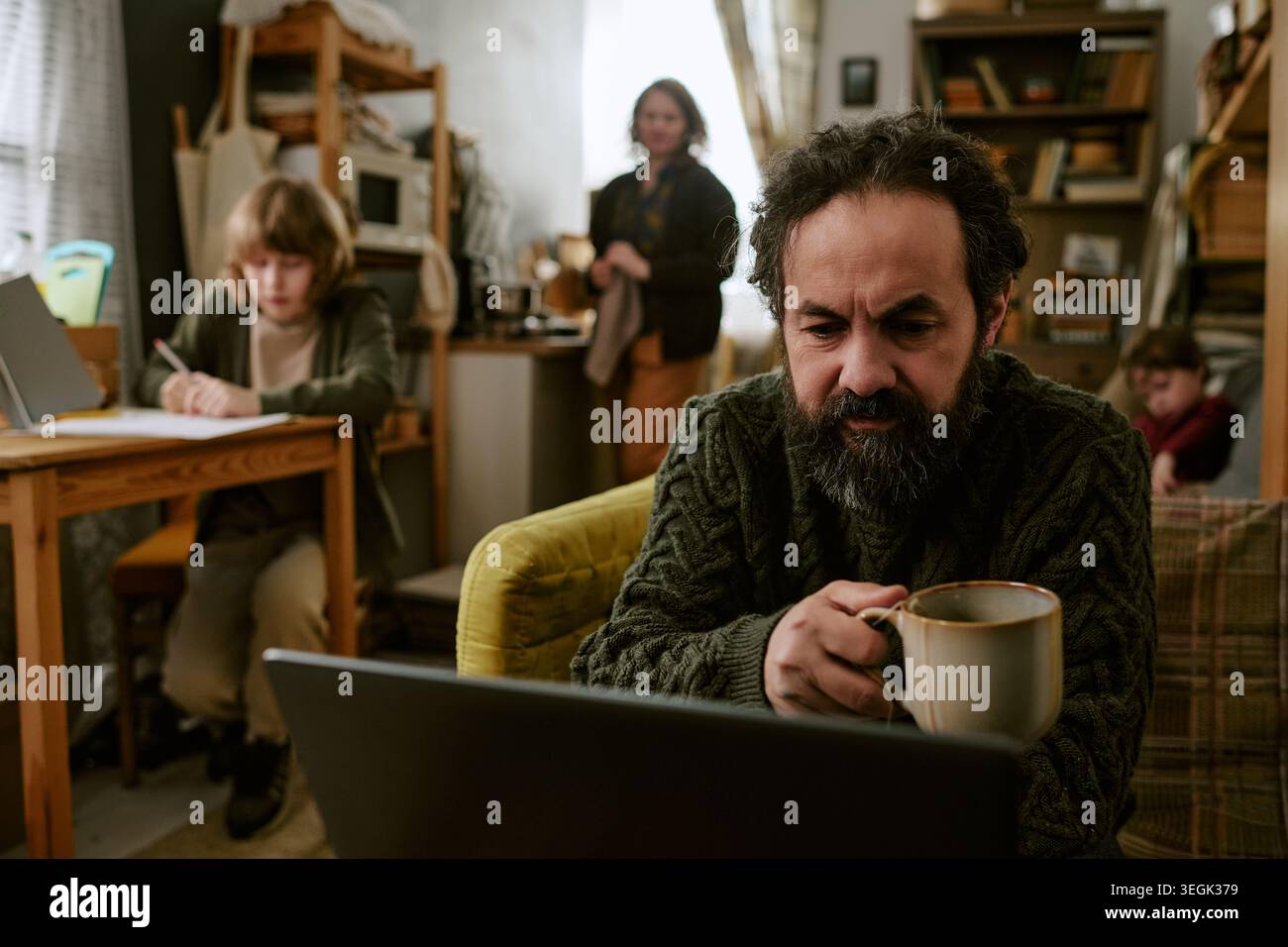 Uomo di mezza età che lavora su un notebook in difficoltà finanziarie a casa Foto Stock