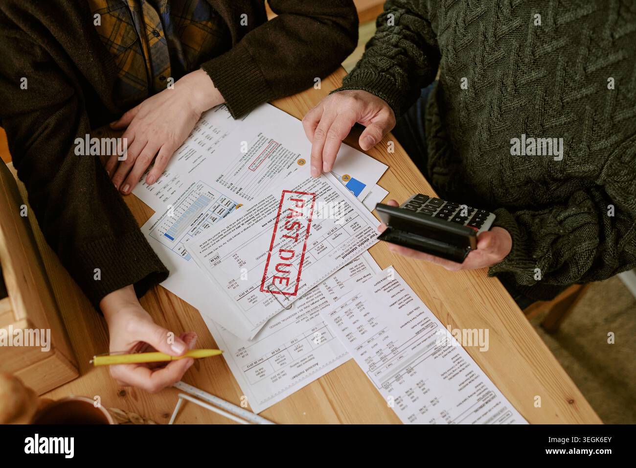 Coppia di adulti che esamina le fatture scadute e calcola il debito Foto Stock