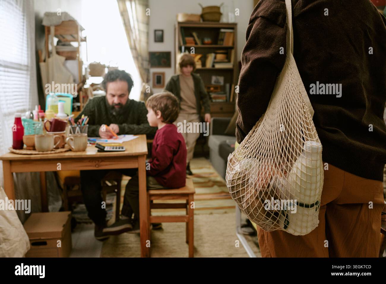 Famiglia povera che gestisce il budget della famiglia mentre i genitori trasportano generi alimentari Foto Stock
