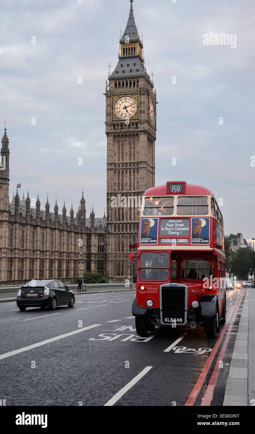 Immagine di un iconico autobus storico degli anni '1940 con il Big Ben e il Parlamento dietro il ponte di Westminster di mattina presto Foto Stock