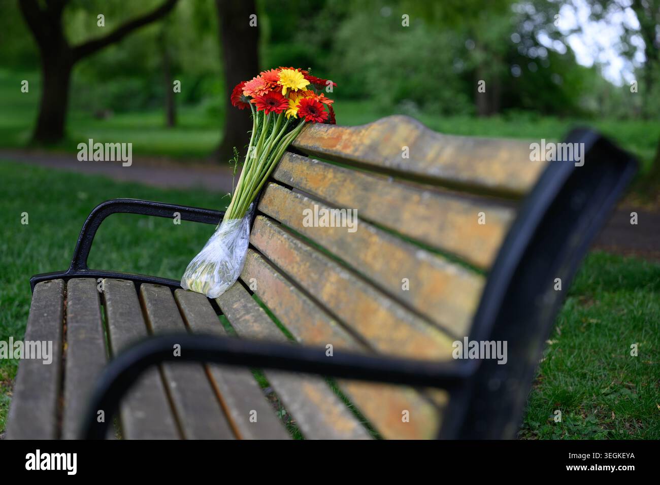 Panca da parco con un bouquet di fiori Foto Stock