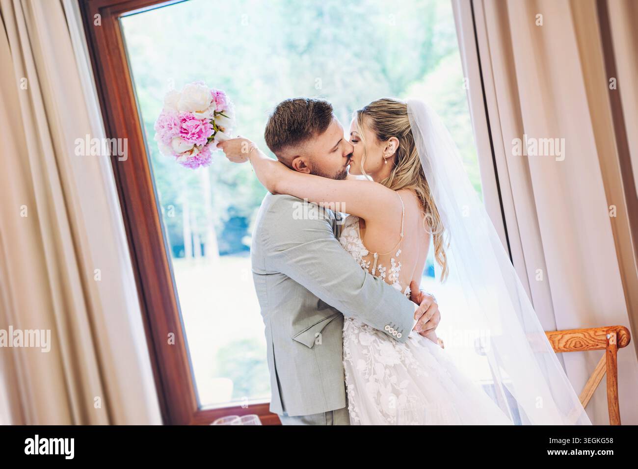 felice, ridendo sposa e sposo che si baciano al matrimonio. Festeggiate un matrimonio emozionante. Foto Stock