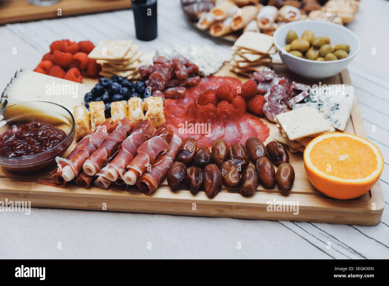 Il pannello di legno contiene salumi e frutta assortiti Foto Stock