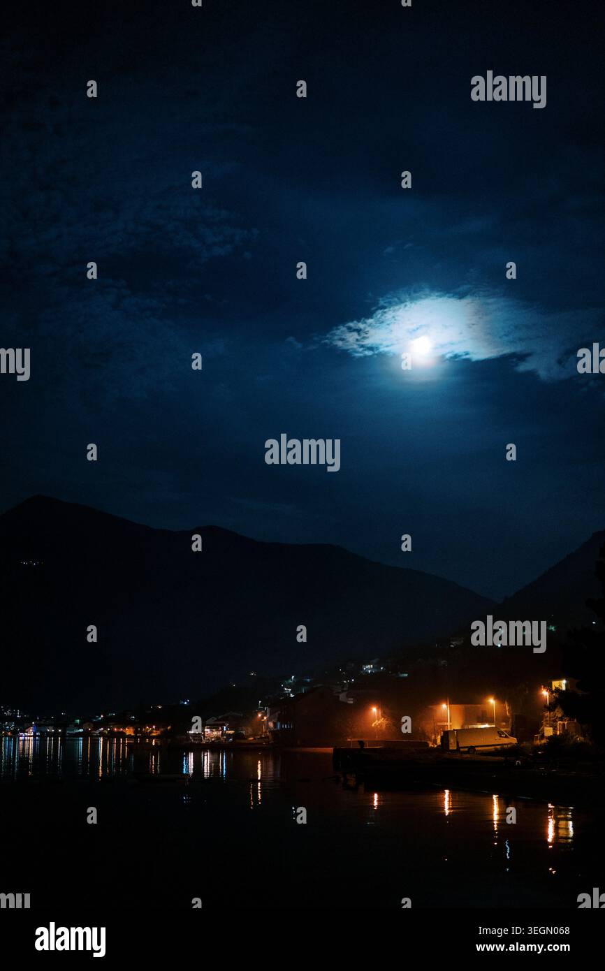 Porto tranquillo sotto il cielo stellato. Le acque calme e le montagne sagomate creano un ambiente tranquillo Foto Stock