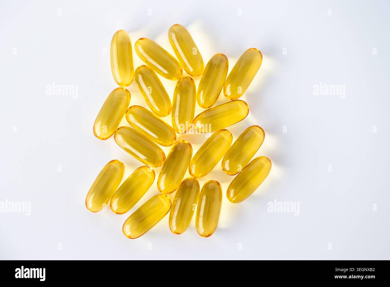Capsule softgel di olio di pesce omega-3 dorate isolate su sfondo bianco. Top View integratore alimentare per salute, benessere e nutrizione. Foto Stock