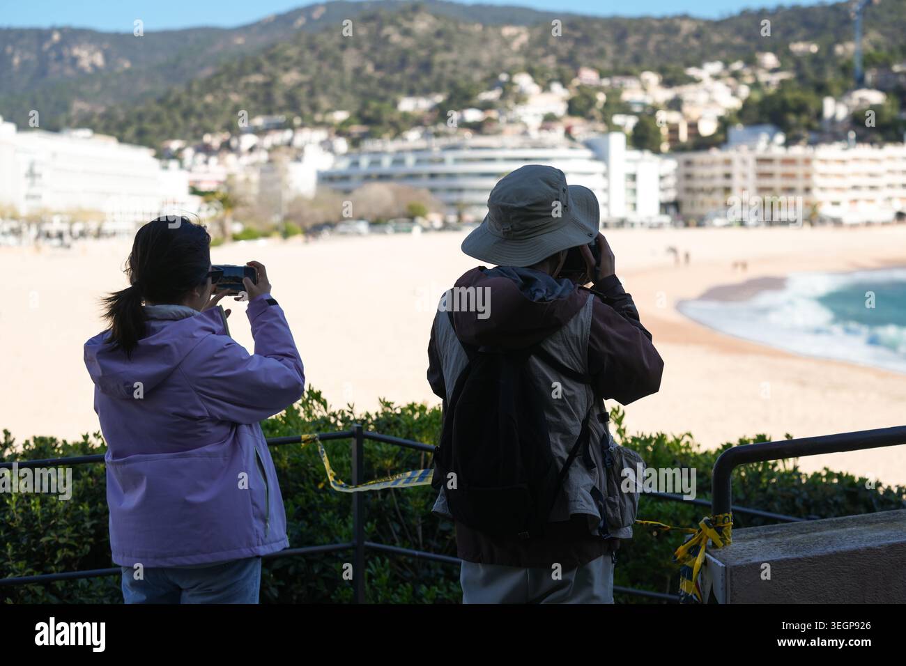 Visitatori che si affacciano sulla spiaggia di Platja Gran a Tossa de Mar, una città costiera situata sulla Costa Brava in Catalogna, Spagna Foto Stock