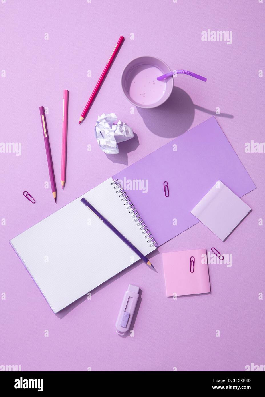 Un vivace spazio di lavoro color pastello, con una varietà di strumenti e materiali, è predisposto per un progetto creativo. Foto Stock