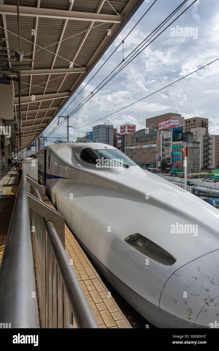 Nagoya, Giappone - 18 settembre 2025: Il grandangolo del treno proiettile Nozomi Shinkansen si ferma alla stazione di Nagoya. Vista a livello del passeggero, il naso allungato del veicolo principale. Foto Stock