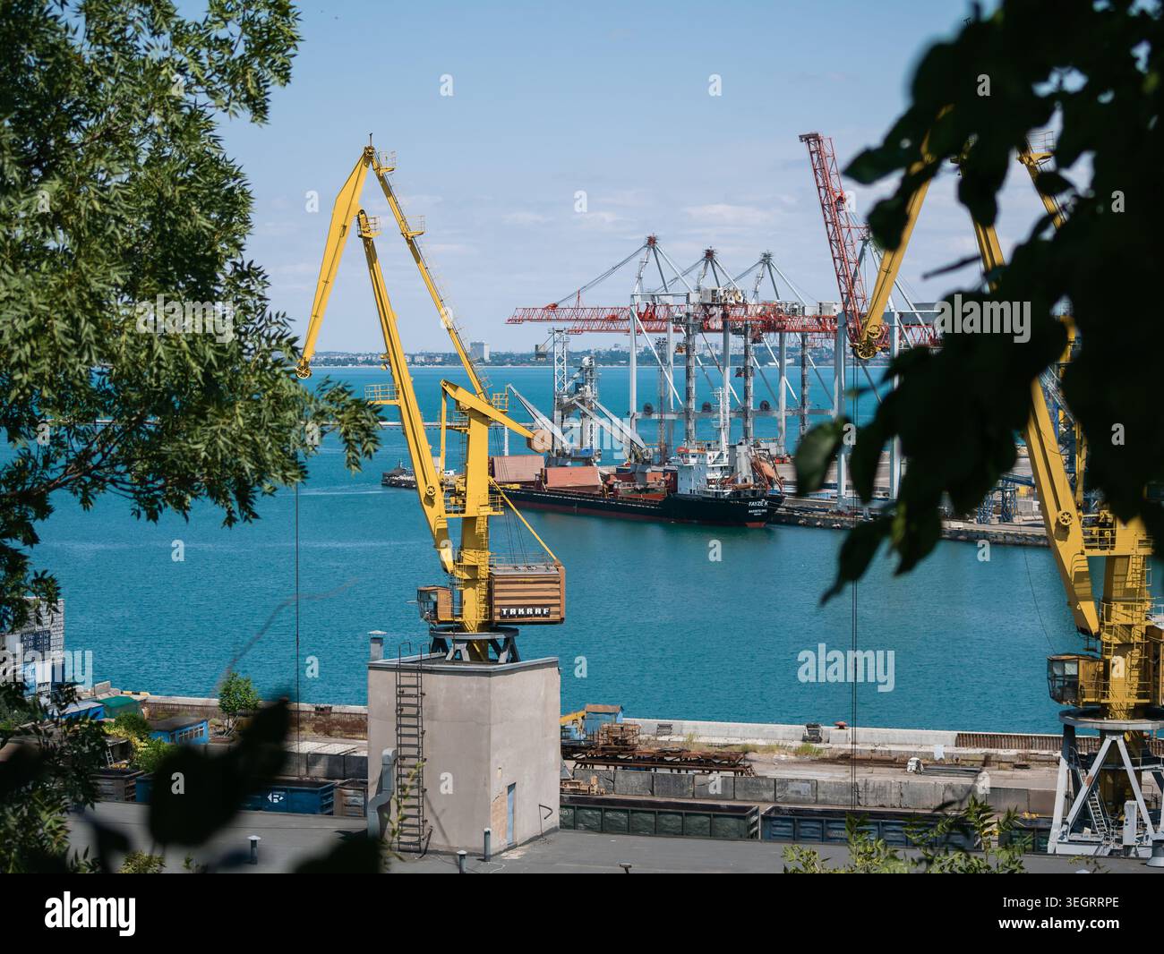 Odesa, Ucraina - 10 luglio 2025: Ormeggi e gru portuali presso il porto marittimo di Odessa, che mostrano le infrastrutture marittime e le operazioni sul molo Foto Stock
