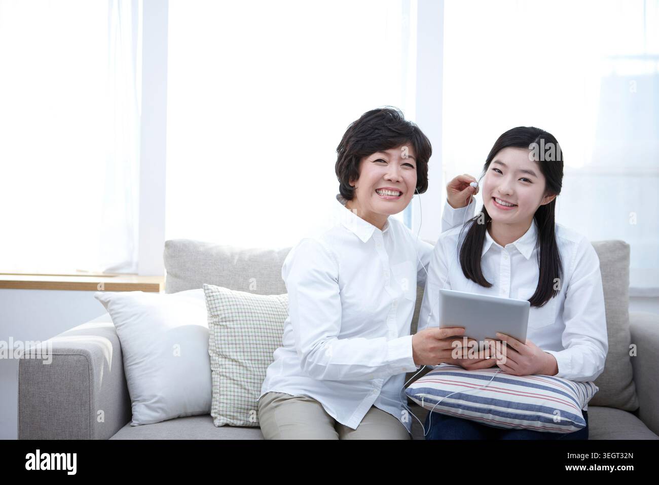 Madre e figlia utilizzando tablet PC insieme su un lettino Foto Stock