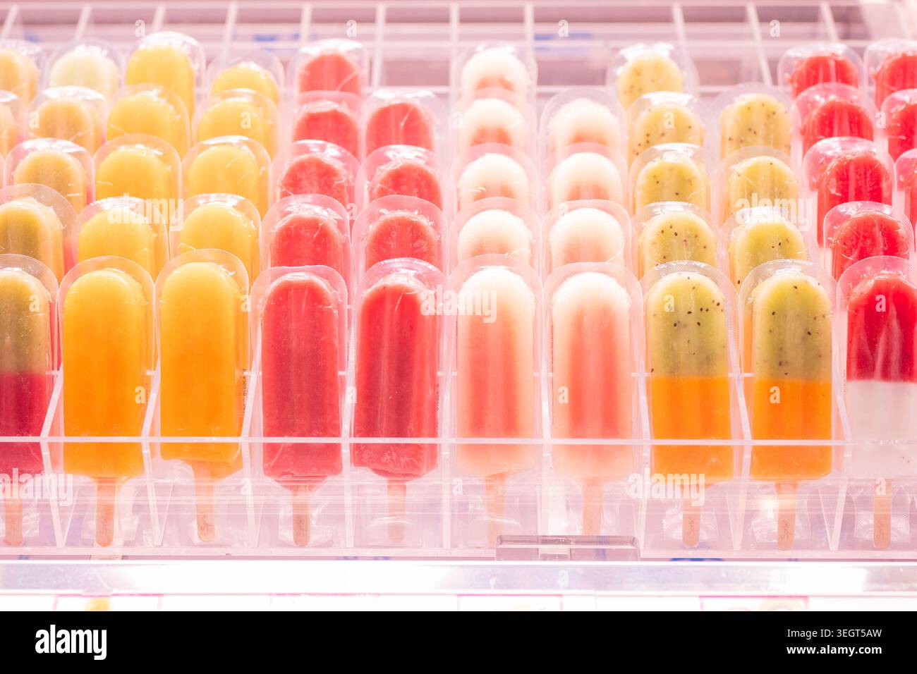 Colorato assortimento di ghiaccioli e papaveri di frutta fresca in confezioni di plastica esposte in un congelatore presso il famoso mercato pubblico la Boqueria di barca Foto Stock
