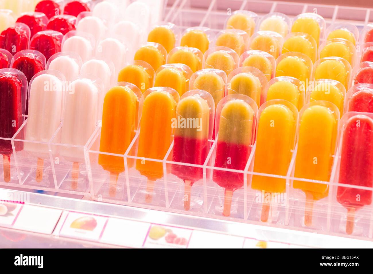 Colorato assortimento di ghiaccioli e papaveri di frutta fresca in confezioni di plastica esposte in un congelatore presso il famoso mercato pubblico la Boqueria di barca Foto Stock