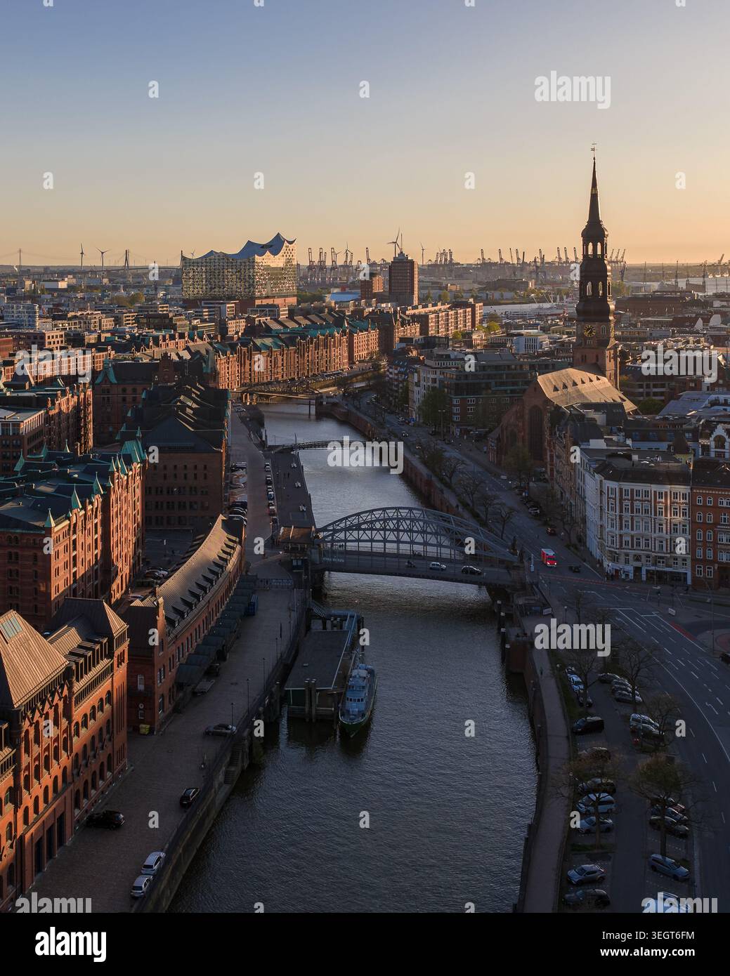 Vista aerea del quartiere di Speicherstadt con storici magazzini in mattoni, l'Elbphilharmonie e la chiesa di Santa Caterina al tramonto ad Amburgo, Hambur Foto Stock