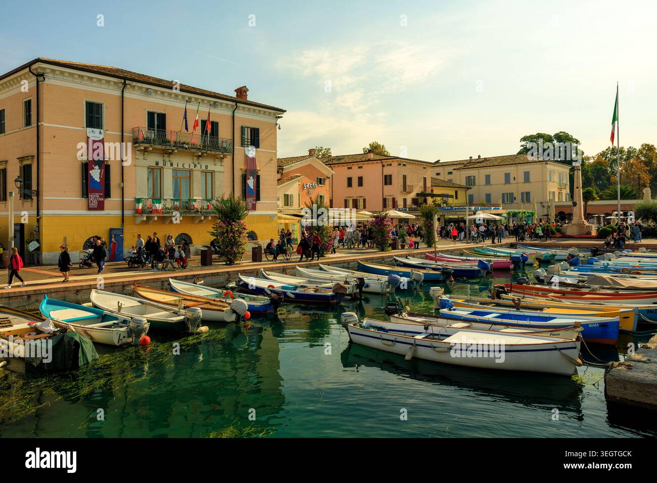 Bardolino, Italia - 20.05.2026: Un'ampia ripresa a livello degli occhi cattura la pittoresca passeggiata lungolago di Bardolino sul Lago di Garda con motoscafi ancorati e Foto Stock
