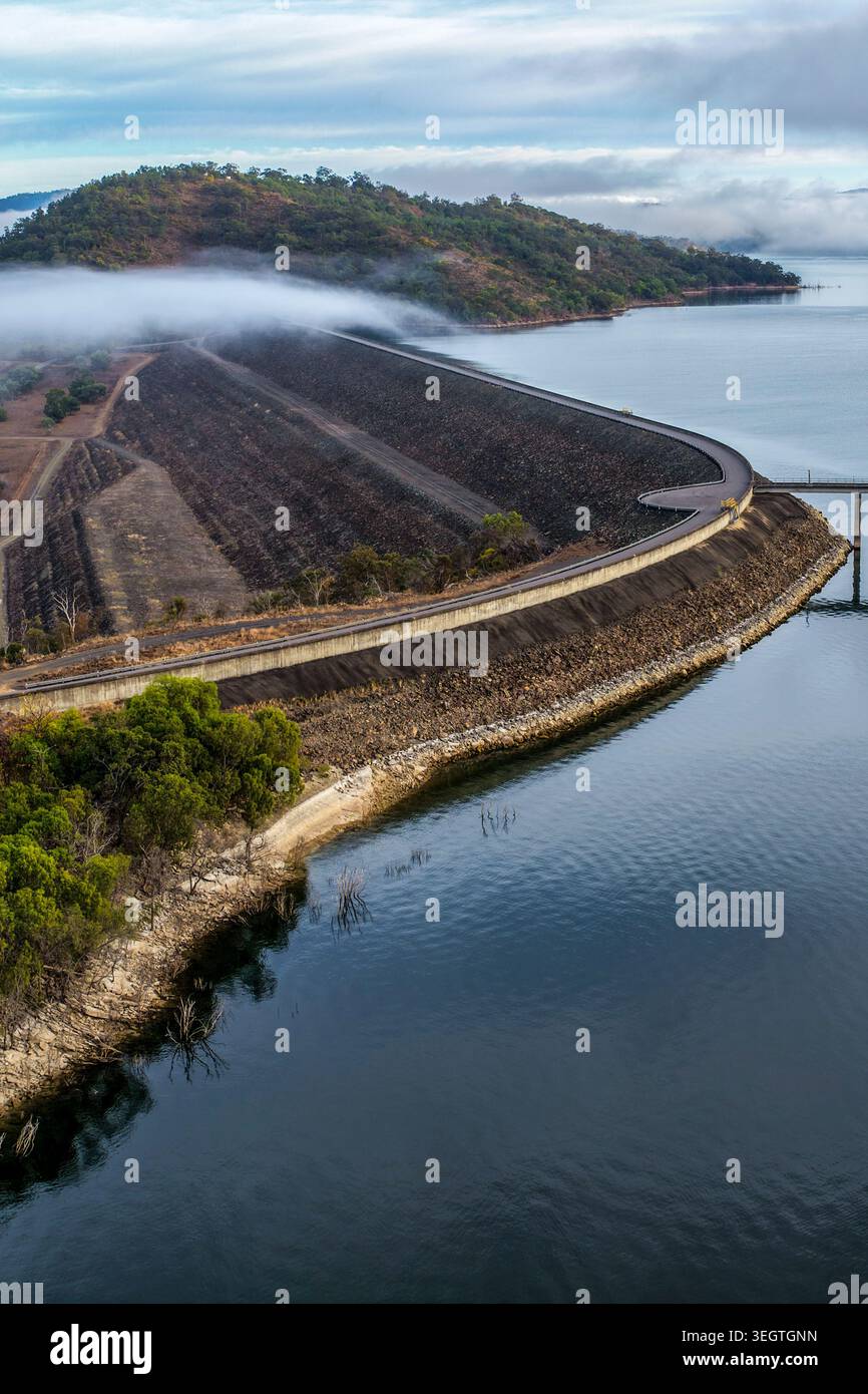Vista verticale dall'alto della parete della diga di Glenbawn con sistema di aspirazione dell'acqua e pontone di manutenzione con nebbia che galleggia sull'acqua nel nuovo Galles del Sud Foto Stock