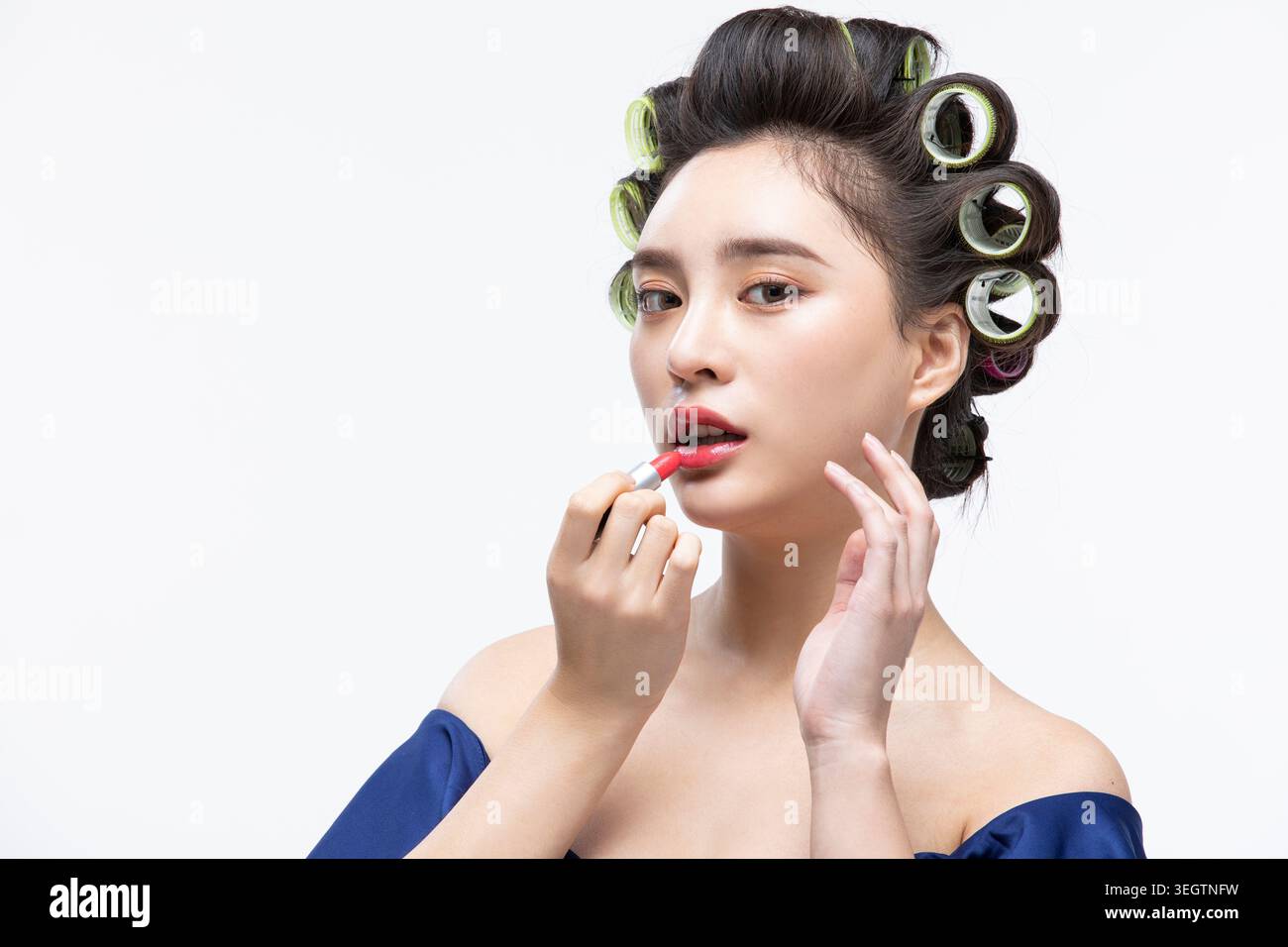 Una donna applica il rossetto in uno studio di bellezza. Foto Stock
