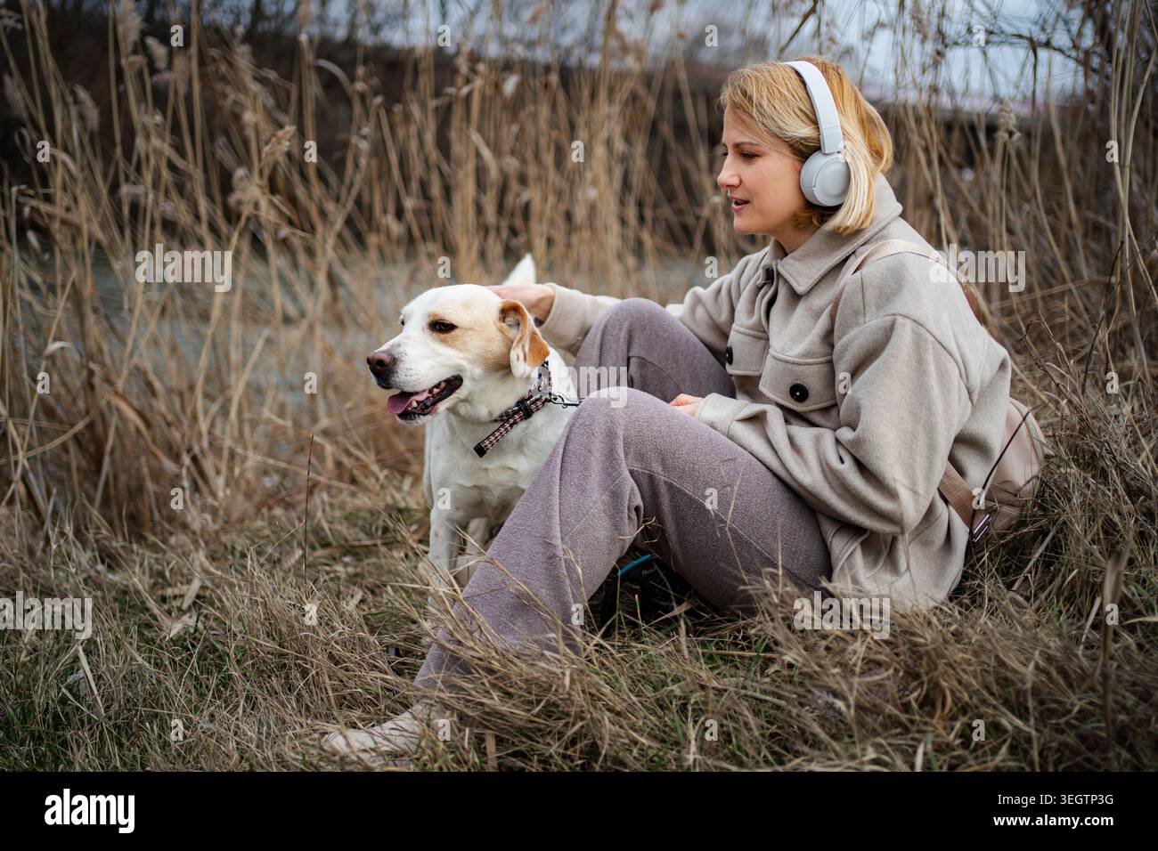 Donna e cane si godono un momento di pace insieme nella natura Foto Stock