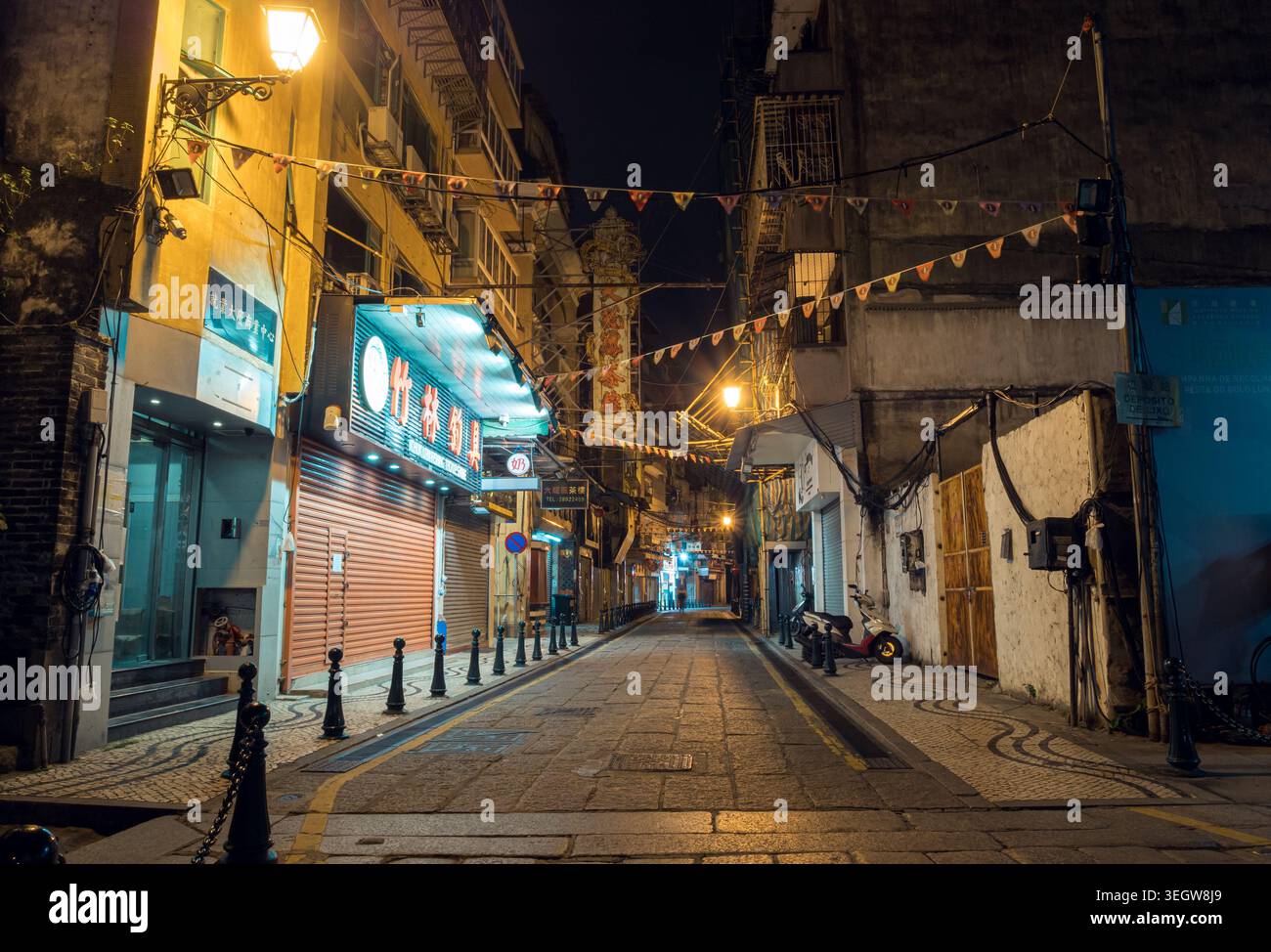 Macao, Cina - 13 marzo 2018: Scena serale di una strada tranquilla di Macao con negozi chiusi e luci di strada che brillano di notte Foto Stock