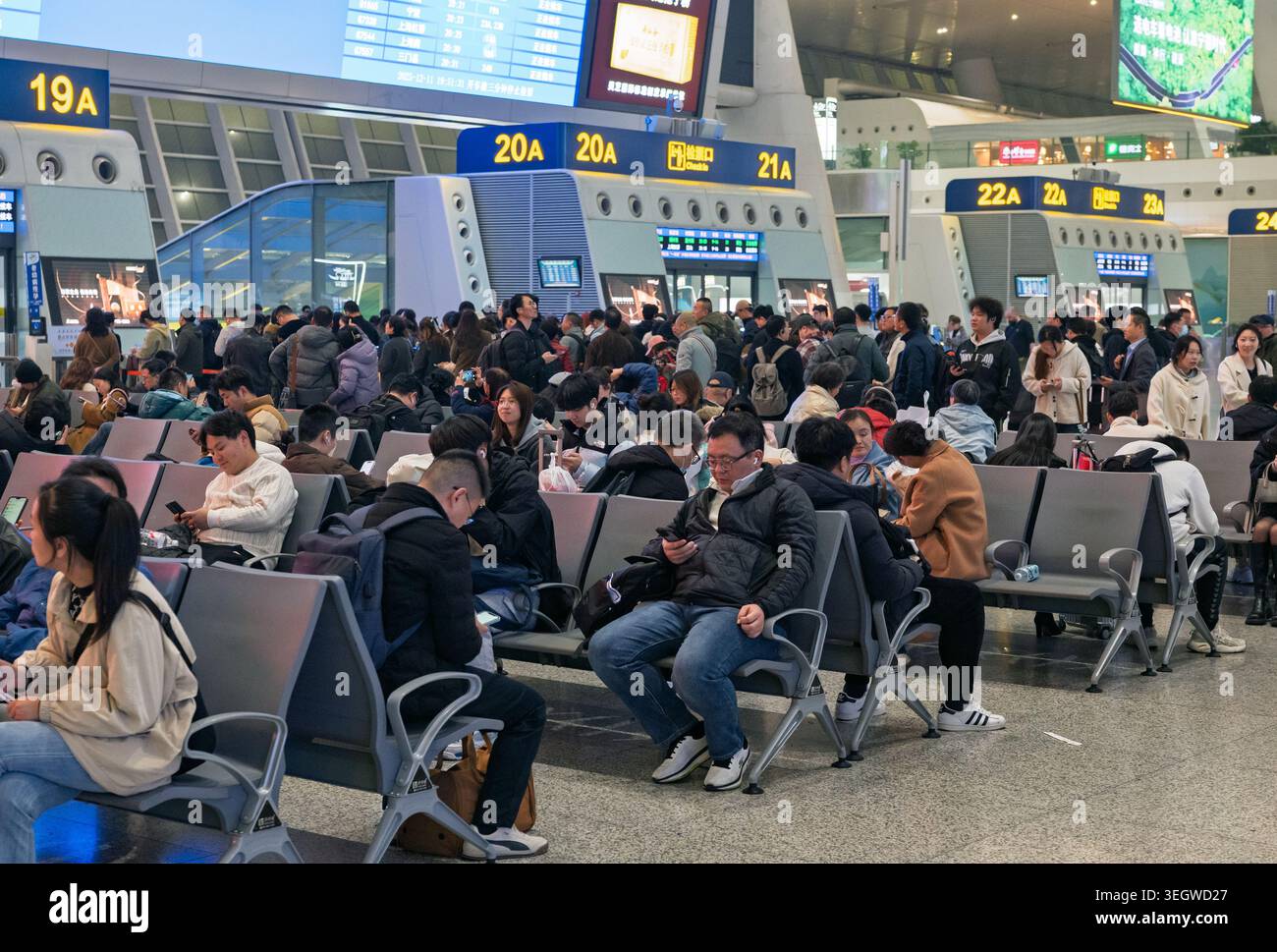 Hangzhou, Cina - 11 dicembre 2025: I viaggiatori attendono in una stazione ferroviaria moderna e affollata in Cina durante un intenso periodo di partenze Foto Stock