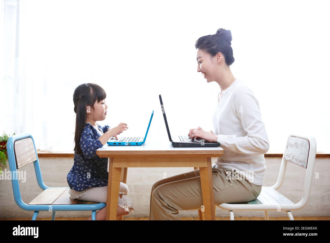 Madre e figlia utilizzando computer portatili sul tavolo Foto Stock