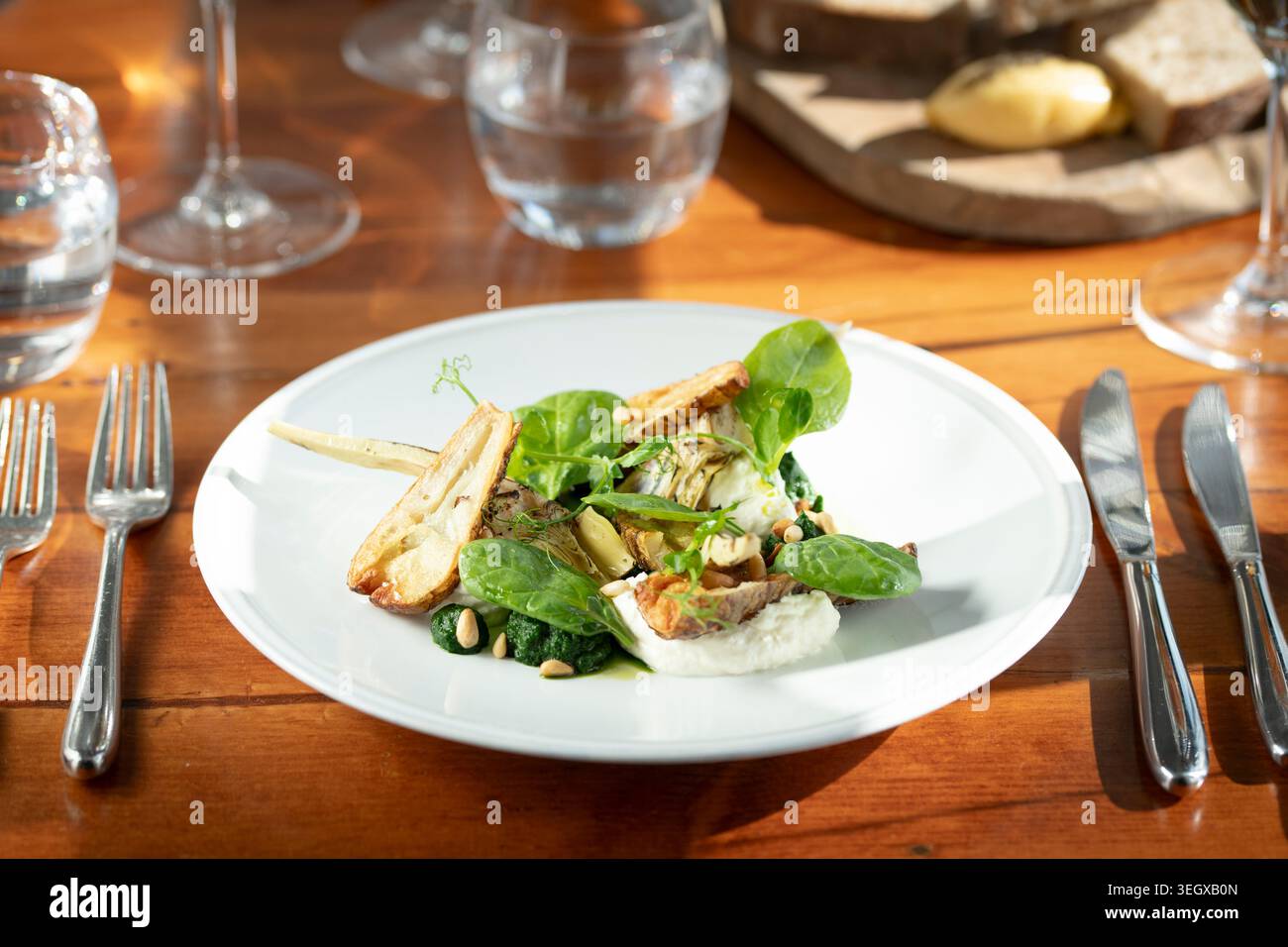 Elegante piatto servito su un tavolo di legno, che cattura l'essenza di un'esperienza culinaria raffinata Foto Stock
