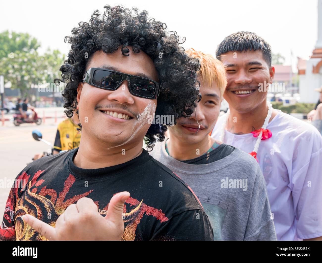 Tre giovani che sorridono e si godono il festival di Songkran a Lampang, Thailandia, con un'atmosfera festosa. Foto Stock