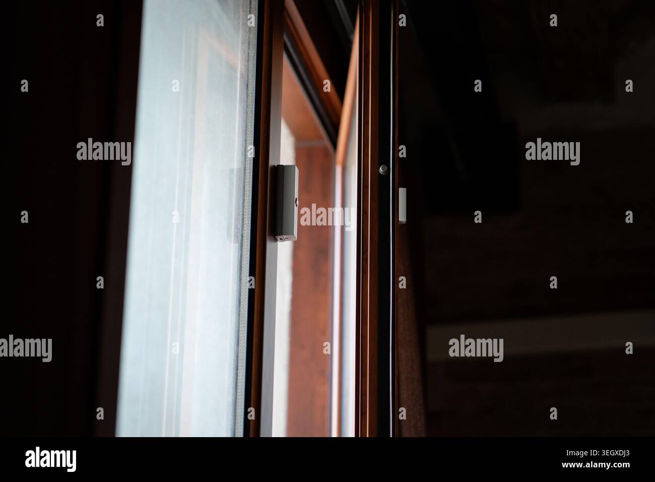 Sensore a contatto magnetico montato su un telaio per finestre in legno Foto Stock