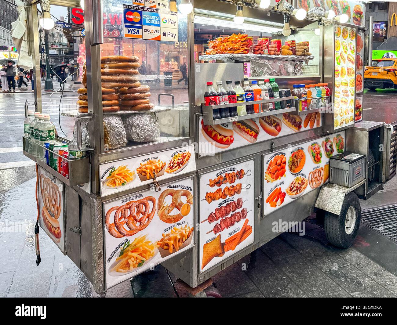 New York City, New York, Stati Uniti d'America - 11 gennaio 2026: Carrello mobile che vende hot dog, pretzel e altri snack caldi in una strada nel centro di Manhattan. Foto Stock