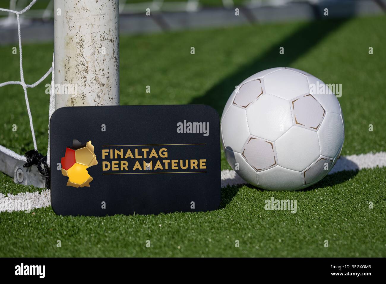 Football, finali amatoriali 2026: Calcio su un campo da calcio e un cartello con il logo ufficiale (inserito digitalmente) Foto Stock