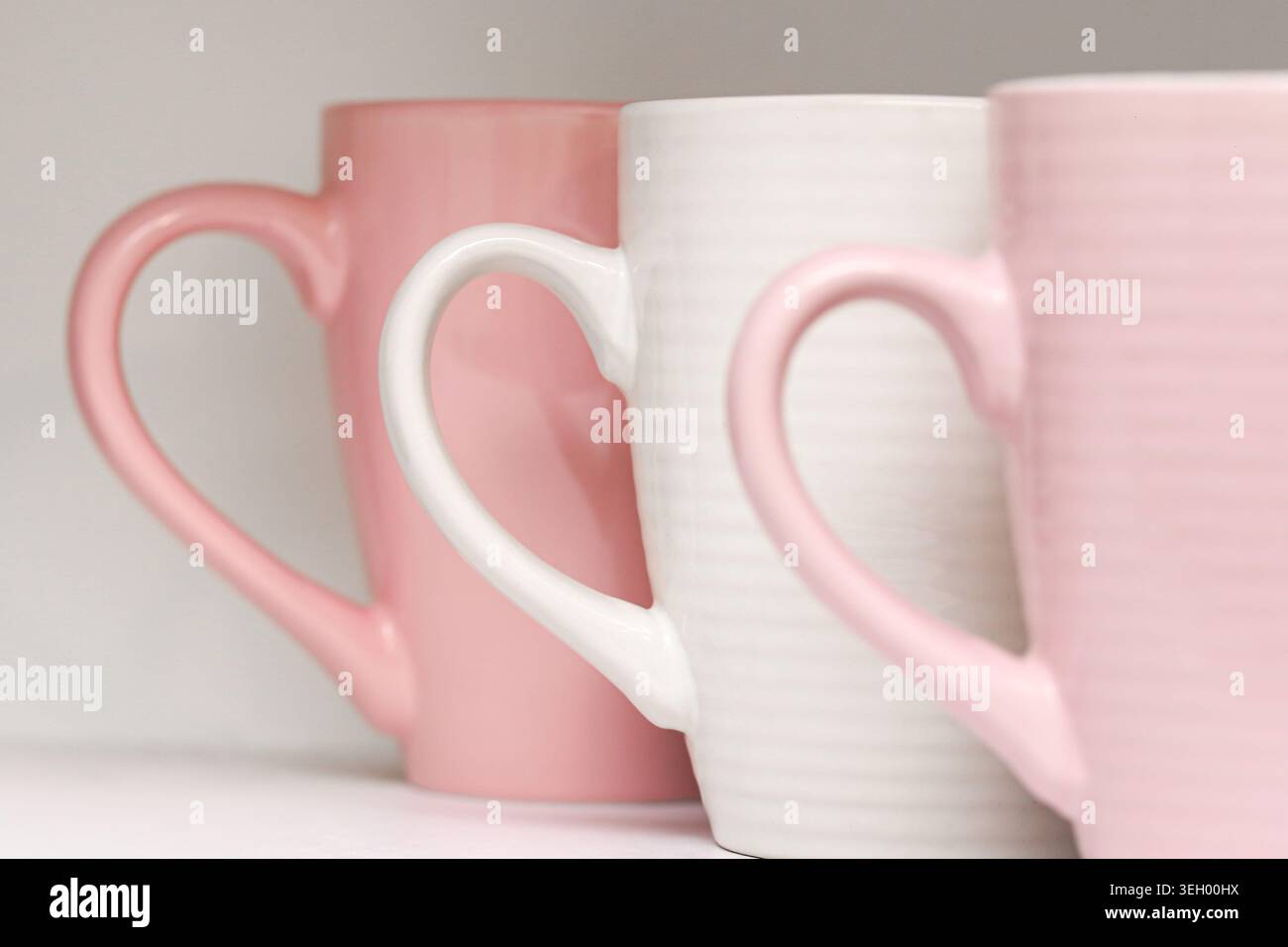 Tazze in ceramica rosa in primo piano. Stoviglie minimali da cucina e stoviglie moderne con tazze color pastello all'interno. Foto Stock