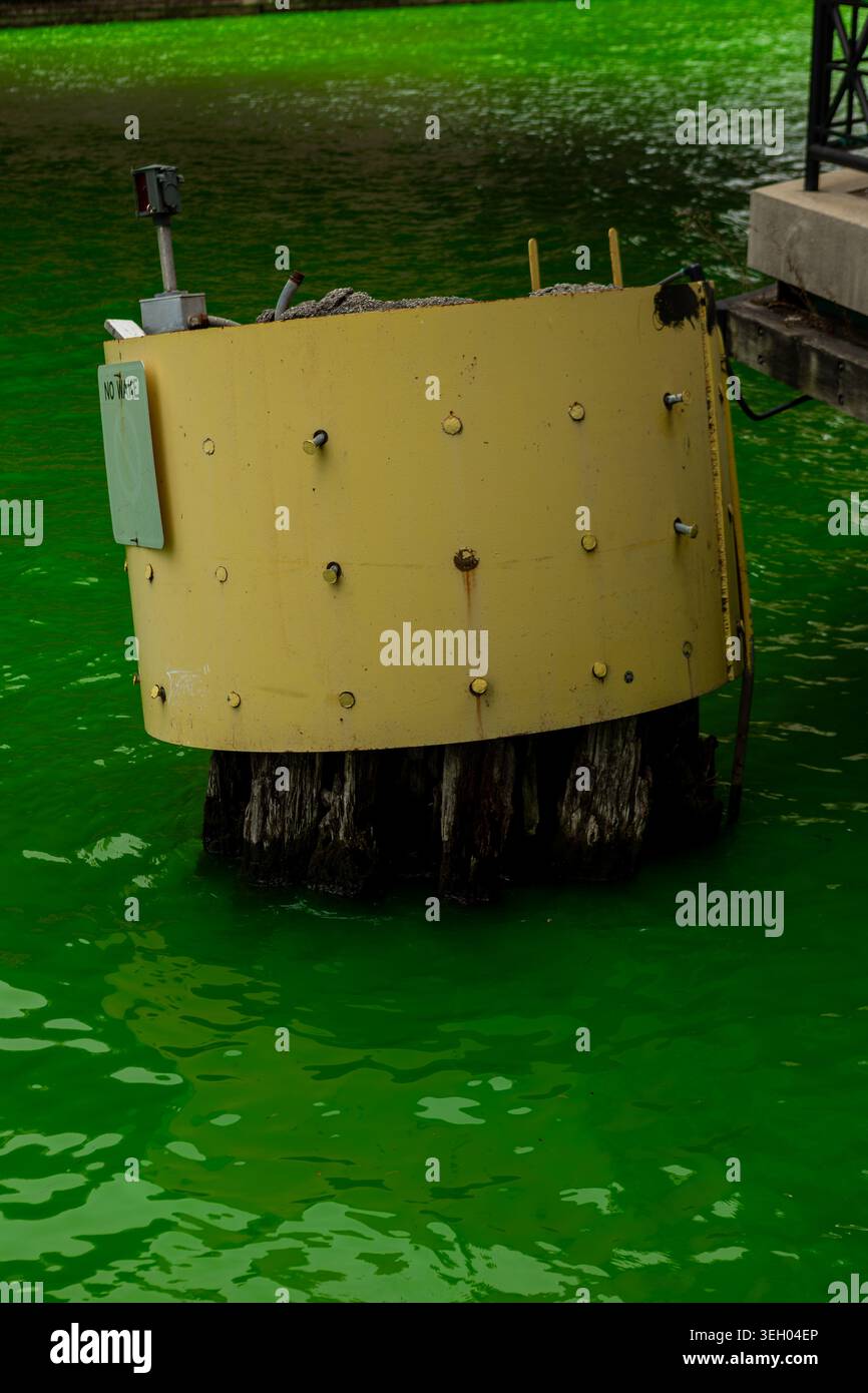 La folla si riunisce a Chicago mentre il fiume diventa verde brillante per celebrare il giorno di San Patrizio. L'evento attira sia la gente del posto che i turisti che celebrano l'IR Foto Stock